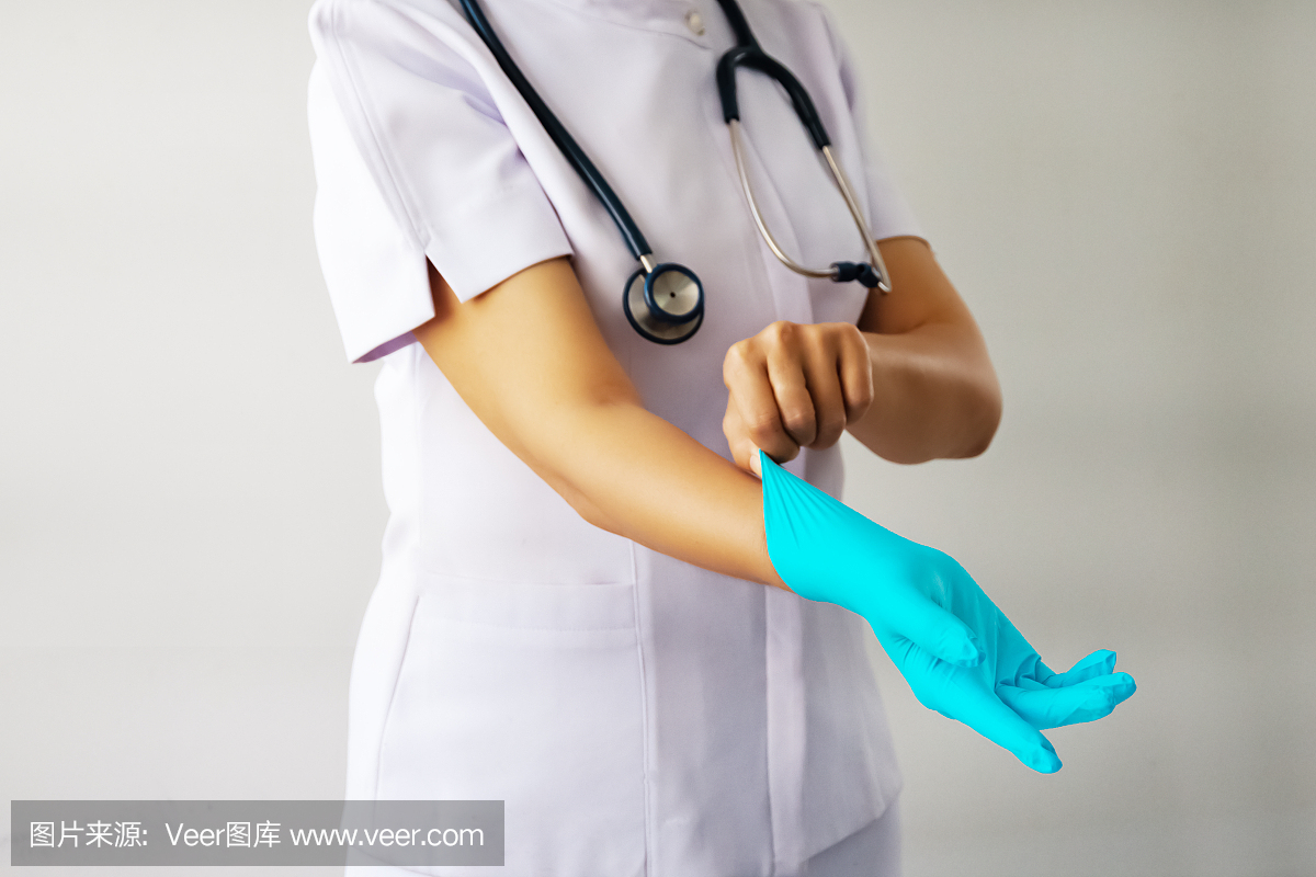 医生手戴蓝色消毒手术手套在手,以保护、保健和医疗为理念